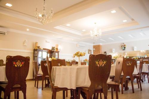 uma sala de jantar com mesa, cadeiras e lustres em Edelweiss Pomerode em Pomerode