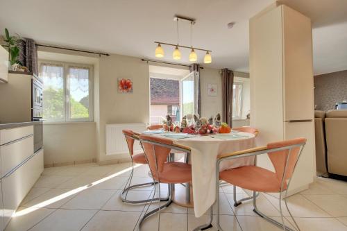 a kitchen with a table and chairs in a kitchen at Gîte Le 1602 in Saint-Nabor