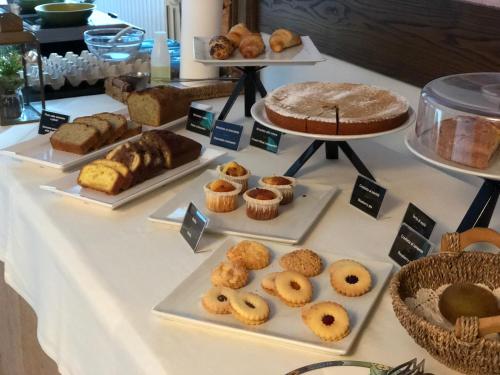 a table with many different types of pastries and cakes at Olimpia Hotel in Bormio