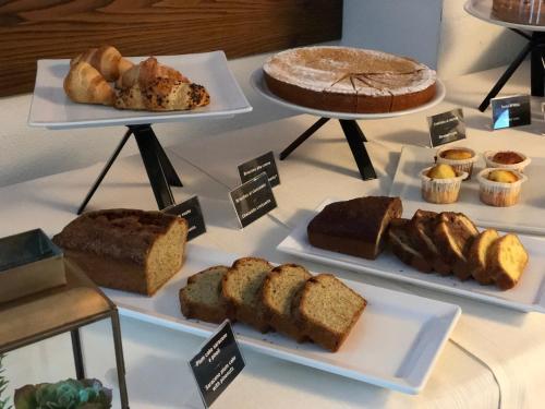 a table topped with cakes and pastries on top of plates at Olimpia Hotel in Bormio