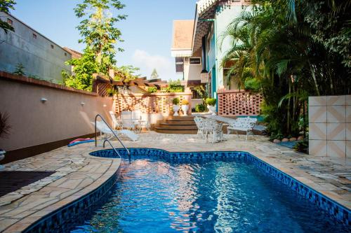 a swimming pool with a table and chairs next to a house at Edelweiss Pomerode in Pomerode