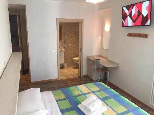 a small room with a bed and a bathroom at Hotel alle Rose in Cavedago