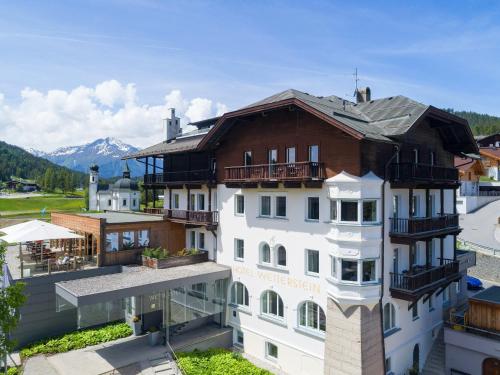a large white building with balconies on top of it at Hotel Wetterstein Seefeld in Seefeld in Tirol