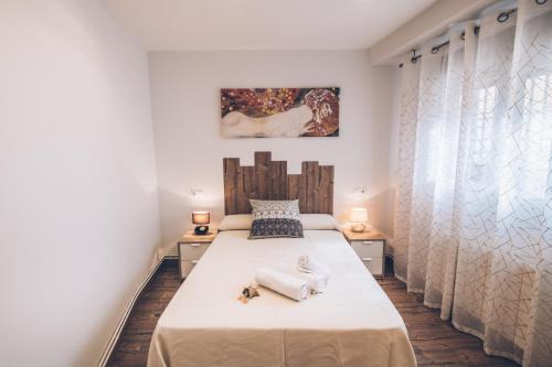 een slaapkamer met een groot bed in een kamer met gordijnen bij VUT elBALCONdelHUECAR in Cuenca