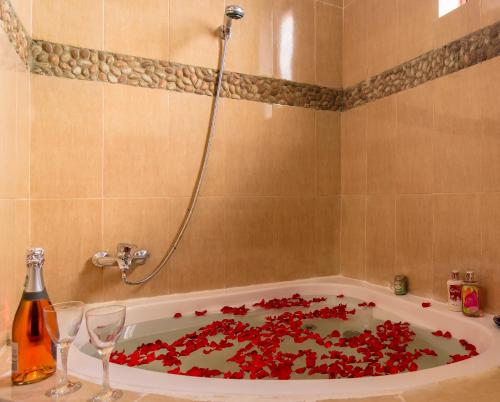 a bath tub filled with red petals in a bathroom at Rayan Apartments & Safaris in Arusha