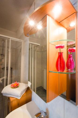 baño con 2 jarrones rojos en un estante en Gasthof Oberer Gesslbauer, en Stanz Im Murztal
