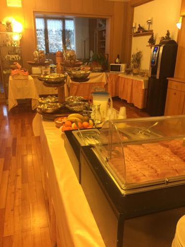 a buffet line with food on it in a kitchen at Hotel alle Rose in Cavedago
