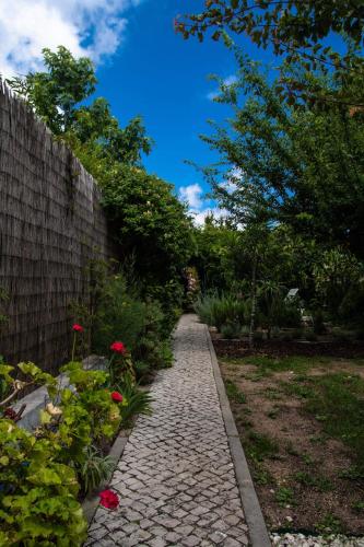 a stone path next to a fence and flowers at Casa da Anita in Aldeia do Meco