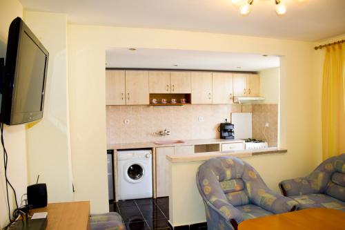 a living room with two chairs and a kitchen at ,,Дироси'' in Sveti Vlas