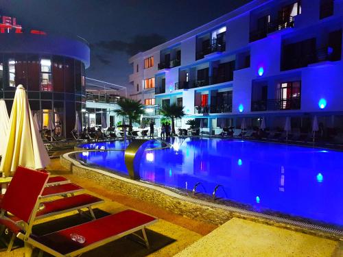 a swimming pool in front of a hotel at night at Hotel ANTAG in Shëngjin