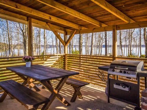 a picnic table and a grill on a wooden deck at Holiday Home Karhulinna by Interhome in Miehoila