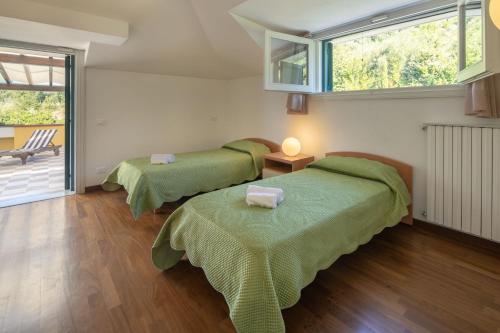 sypialnia z 2 łóżkami i balkonem w obiekcie Villa Lunense by VacaVilla w mieście Avenza