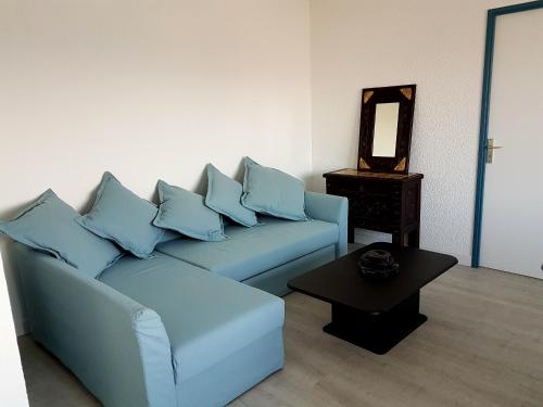 a living room with a blue couch and a table at Réf 542 Seignosse océan , bel appartement avec parking privatif, à 250m de la plage, 5 personnes in Seignosse