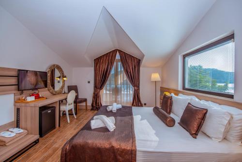 a bedroom with a large bed with a desk and a window at S3 Seahorse Beach Club in Oludeniz