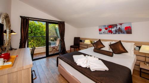 a bedroom with a bed and a desk and a window at S3 Seahorse Beach Club in Oludeniz