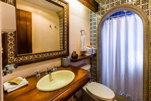 a bathroom with a sink and a toilet and a mirror at Hotel Lunata - 5th Avenue in Playa del Carmen