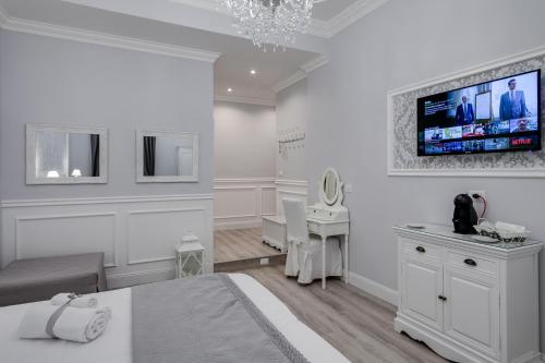 a white room with a bed and a tv on the wall at Charme & Chic Luxury in Rome