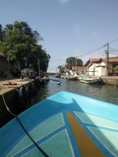 a boat in a river with boats in it at Gloriya Mathews in Negombo