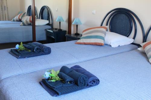 two beds with blue towels and pillows on them at Vila Marachique V Alvor in Alvor