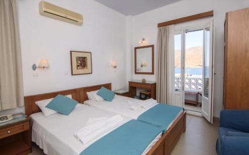 Habitación de hotel con cama y balcón en Miké Hotel, en Egíali