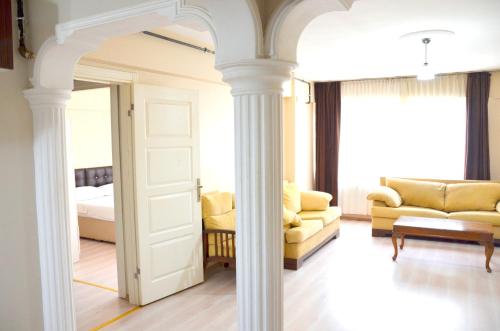 a room with columns and a bed and a couch at Elit Apartments and Suites Corlu in Çorlu