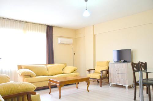 a living room with a couch and chairs and a tv at Elit Apartments and Suites Corlu in Corlu