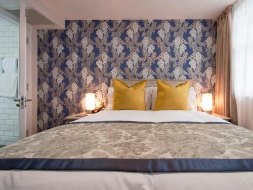 a bedroom with a large bed with yellow pillows at W12 Rooms in London