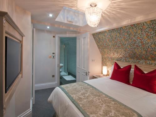 a bedroom with a large bed with red pillows at W12 Rooms in London