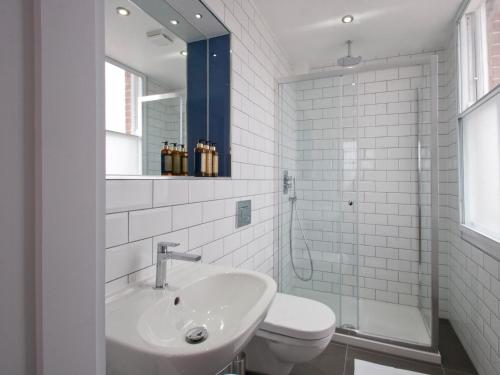 a bathroom with a sink and a toilet and a mirror at W12 Rooms in London