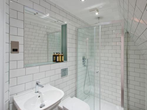 a white bathroom with a sink and a shower at W12 Rooms in London