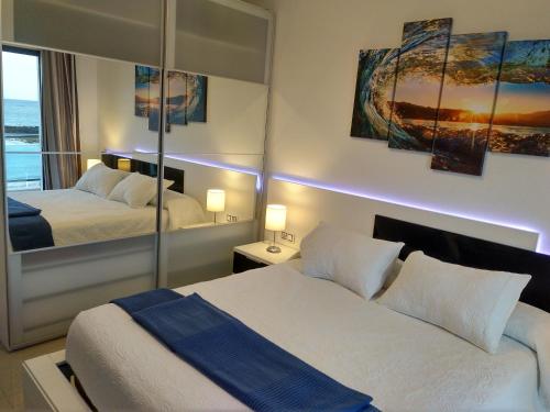 TetirにあるOcean Front Apartment (WiFi)のベッド2台と鏡が備わるホテルルームです。