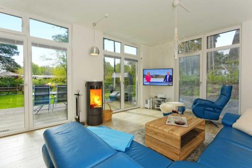 a living room with a blue couch and a fireplace at Kapitaensweg 32 in Ostseebad Karlshagen
