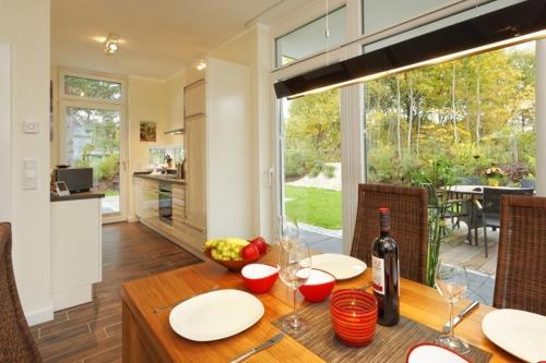 a dining room table with a bottle of wine on it at Kapitaensweg 18 in Ostseebad Karlshagen