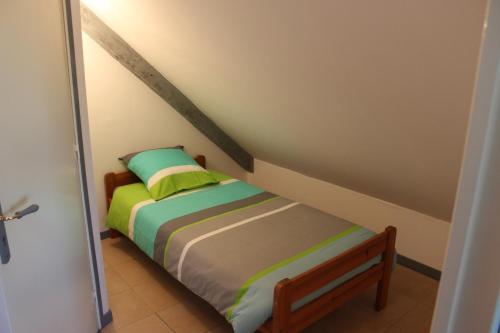 - un petit lit avec des oreillers verts dans l'établissement Chez Marie et christian, à La Boussac