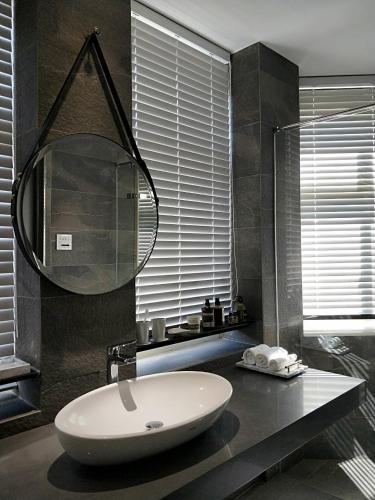 a bathroom with a sink and a mirror on a counter at 小小邸 Small Hotel in Luodong