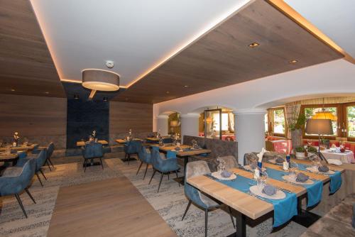 a dining room with tables and chairs at GenussHotel Sonnblick in Sankt Leonhard im Pitztal