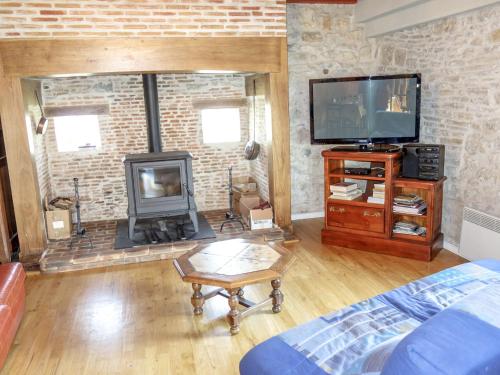 un salon avec une cheminée et une télévision dans l'établissement Holiday Home Maison Bonneval by Interhome, à La Chapelle-aux-Saints