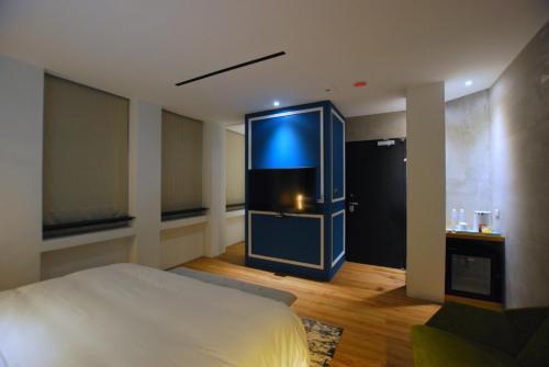 a room with a bed and a large television in it at 小小邸 Small Hotel in Luodong