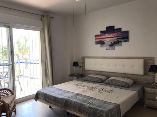 1 dormitorio con cama grande y ventana grande en Luxe Duplex Appartement met private tuin, en Playas de Orihuela