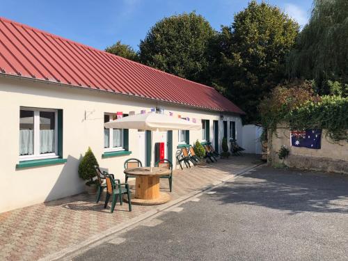 una mesa con sombrilla frente a un edificio en L'auberge fleurie, en Heilly