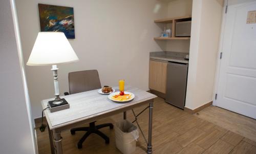 a small table with a lamp and a plate of food on it at Best Western PLUS Monterrey Colón in Monterrey
