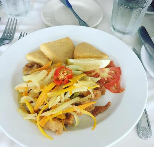 a white plate of food on a table at Hibiscus Lodge Hotel in Ocho Rios