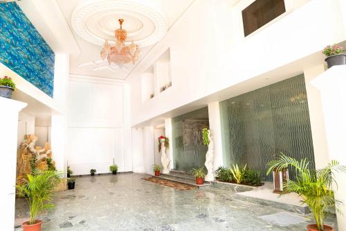a large lobby with a chandelier and potted plants at Sbk Park Inn in Kanchipuram