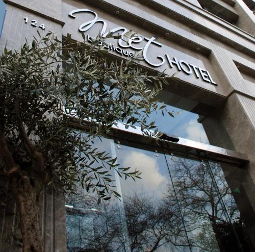 a building with a reflection of the sky in the window at Met Hotel in Izmir