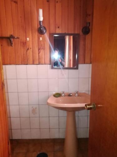 a person taking a picture of a sink in a bathroom at Torres Del Sur Cabañas & Hostal in Villarrica