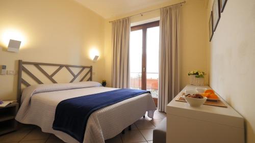 Habitación de hotel con cama y ventana en Residenza Turistico Alberghiera Corallo en Castiglione della Pescaia