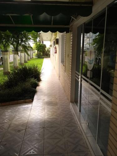 a walkway outside of a building with glass doors at Ville House Hotel Canoas in Canoas