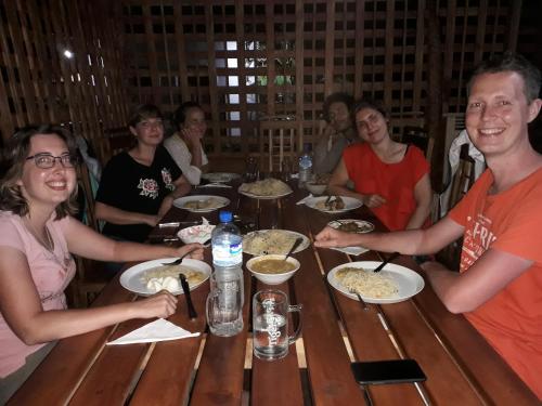 a group of people sitting around a table eating food at Golden Rainbow Guest House in Dambulla