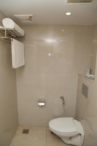 a bathroom with a white toilet in a room at Sbk Park Inn in Kanchipuram