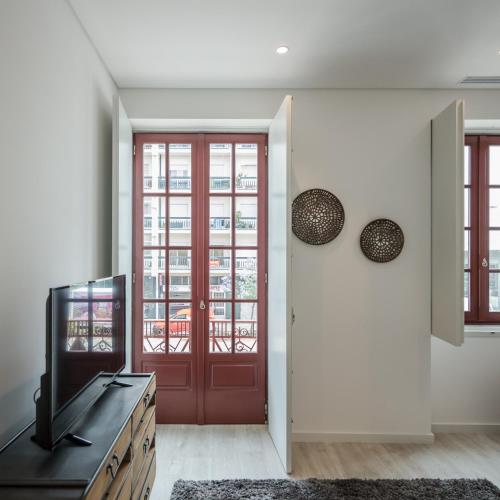 a living room with a red door and a television at Porto Deluxe Suites in Porto